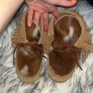 Moccasins, light brown with brown/white cow hide, and fringe on the sides.